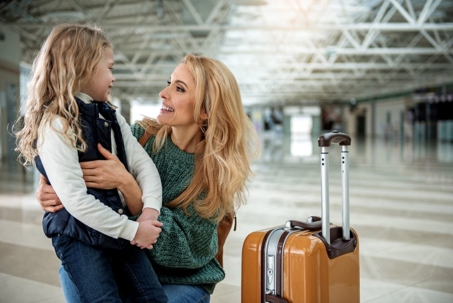 Mom saying goodbye to child at airport