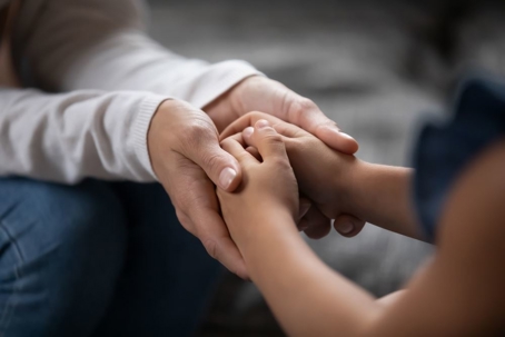 close up of child holding adult hands